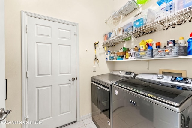 laundry area featuring washer and clothes dryer and light tile patterned floors