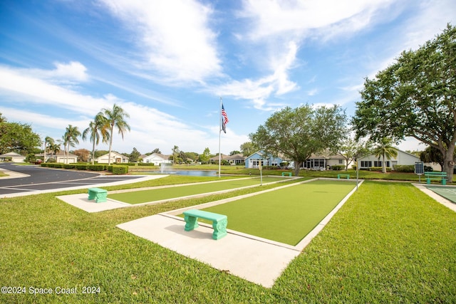 view of property's community with a yard and a water view