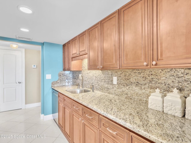 kitchen with dishwasher, sink, light stone counters, backsplash, and light tile patterned floors