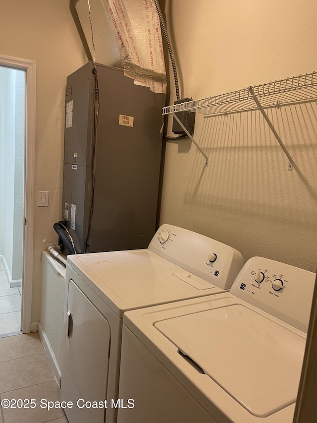 clothes washing area with washing machine and dryer and light tile patterned floors