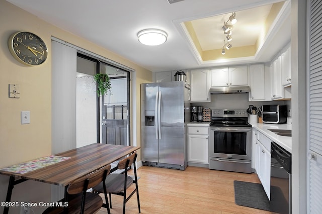 kitchen featuring light hardwood / wood-style floors, white cabinets, appliances with stainless steel finishes, and a raised ceiling