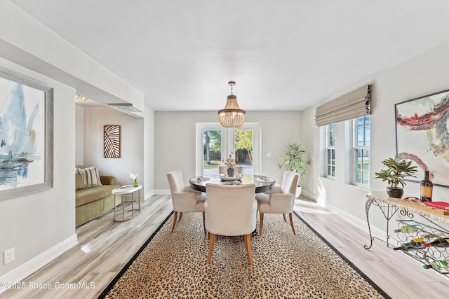 dining area featuring an inviting chandelier and light wood-type flooring