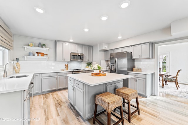 kitchen featuring sink, a wealth of natural light, gray cabinets, and stainless steel appliances