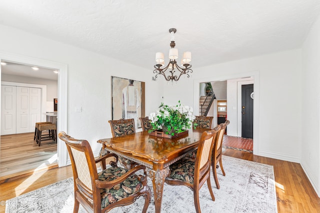 dining space featuring light wood-type flooring and a notable chandelier