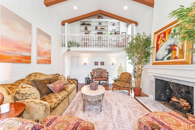 living room featuring beam ceiling, high vaulted ceiling, a high end fireplace, and hardwood / wood-style floors