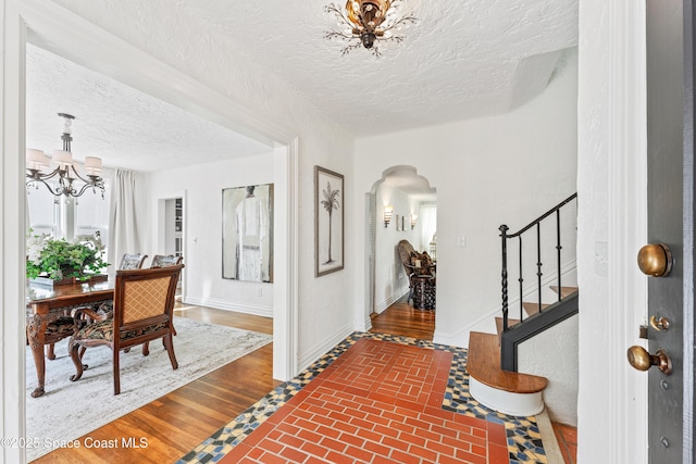 foyer entrance featuring a notable chandelier and a textured ceiling