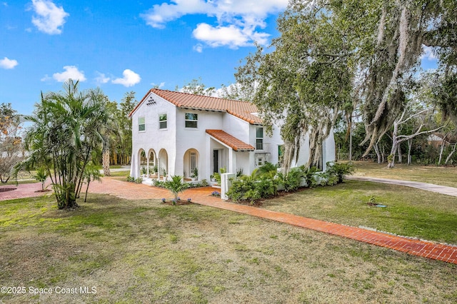 mediterranean / spanish-style house with a front yard