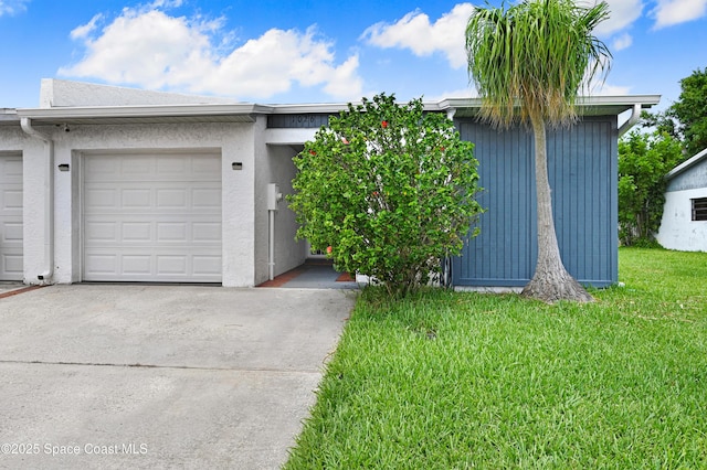 view of front facade featuring an attached garage, stucco siding, concrete driveway, and a front yard