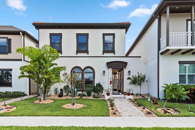 mediterranean / spanish house featuring a front yard