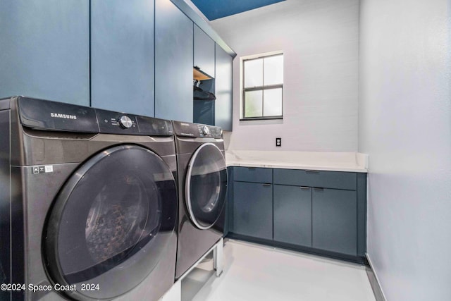 washroom featuring washer and clothes dryer and cabinets