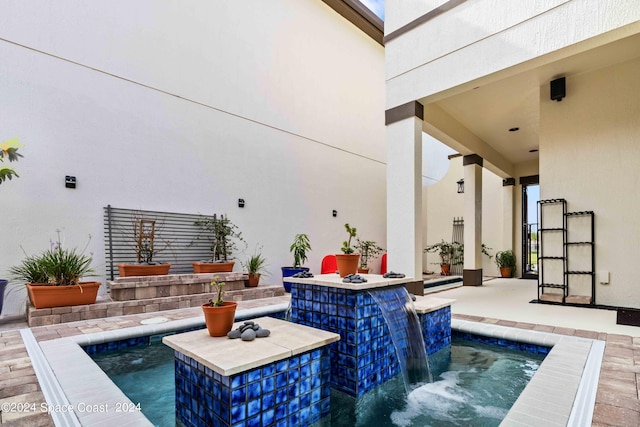 view of pool with a bar and pool water feature