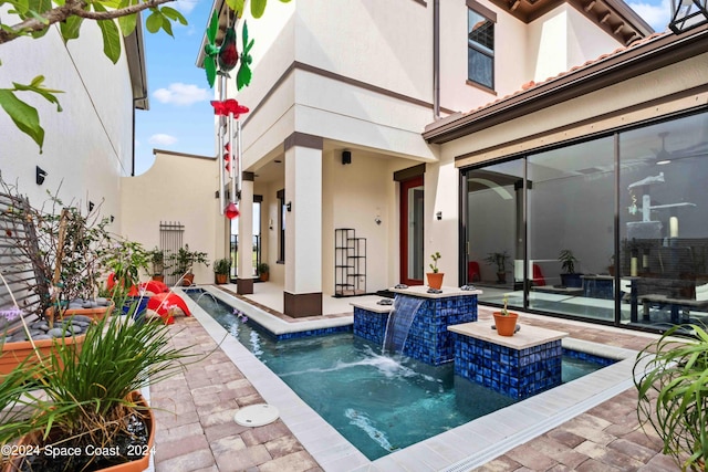 view of pool with pool water feature, a patio area, and a hot tub