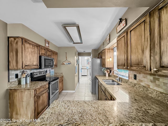 kitchen with tasteful backsplash, appliances with stainless steel finishes, sink, and light tile patterned flooring