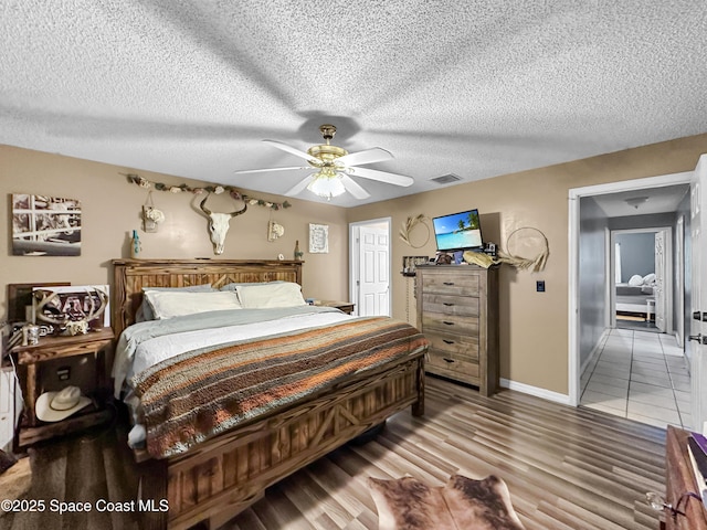 bedroom featuring ceiling fan, a textured ceiling, and hardwood / wood-style flooring