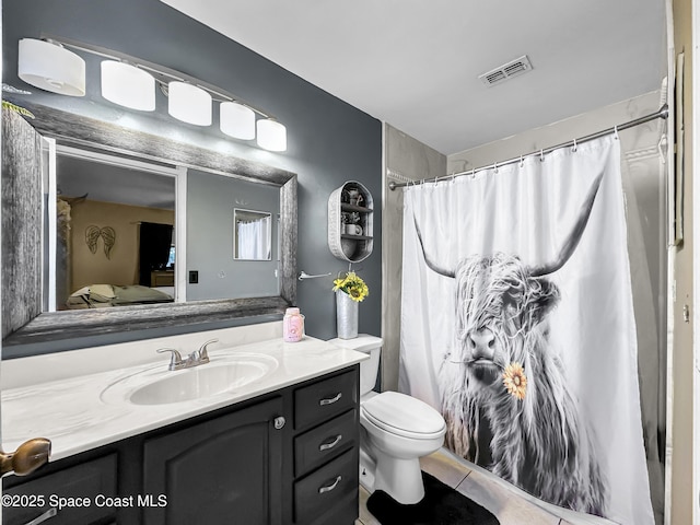 bathroom with toilet, vanity, a shower with curtain, and tile patterned floors