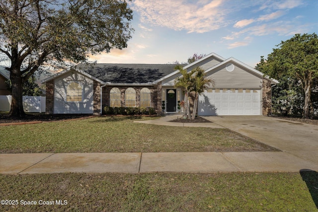 ranch-style house featuring a garage and a lawn