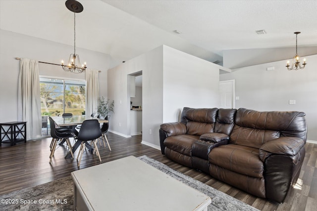 living room featuring lofted ceiling, dark hardwood / wood-style floors, a chandelier, and a textured ceiling