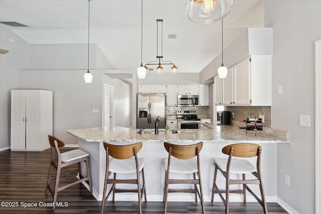 kitchen with sink, white cabinetry, decorative light fixtures, appliances with stainless steel finishes, and kitchen peninsula