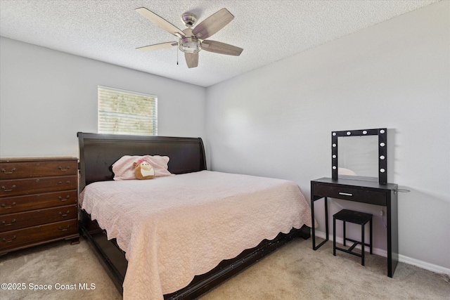 carpeted bedroom featuring ceiling fan and a textured ceiling