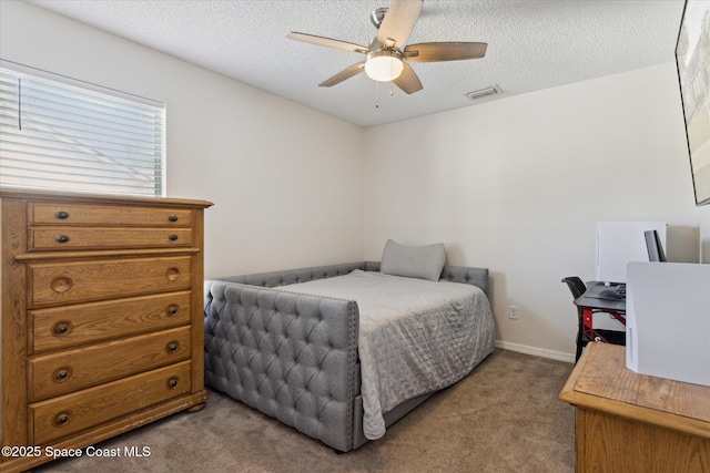 bedroom featuring ceiling fan, light colored carpet, and a textured ceiling