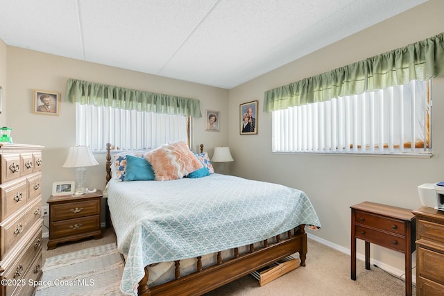 carpeted bedroom featuring multiple windows and a textured ceiling