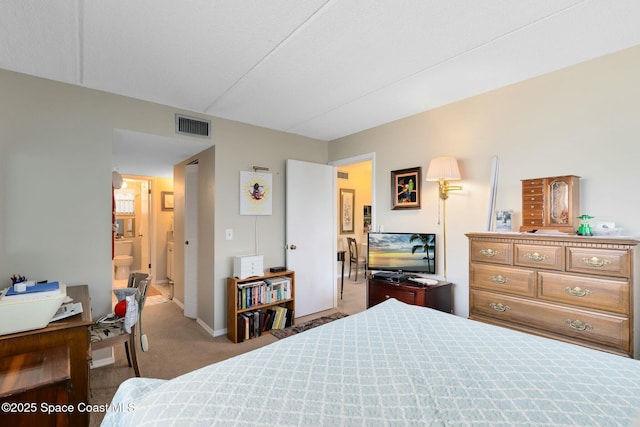 bedroom featuring ensuite bathroom and carpet