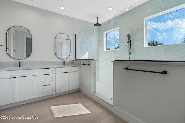 bathroom with hardwood / wood-style flooring, a shower, and vanity