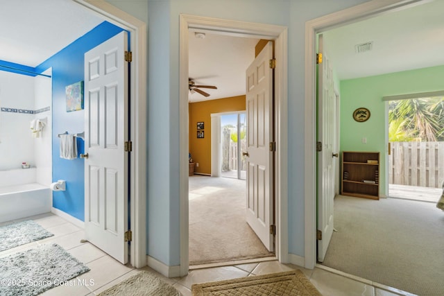 bathroom featuring tile patterned floors, a washtub, and ceiling fan