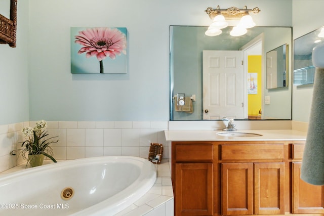 bathroom featuring tiled bath and vanity