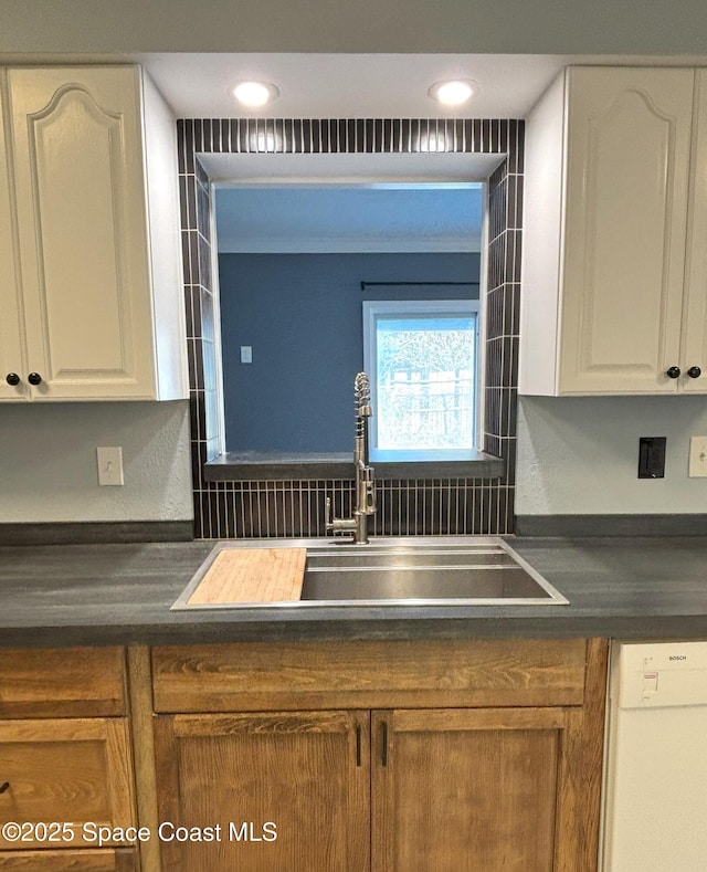 kitchen featuring sink, dishwasher, and white cabinets