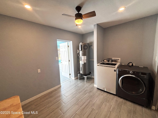 laundry area with water heater, ceiling fan, washer and dryer, and light hardwood / wood-style floors