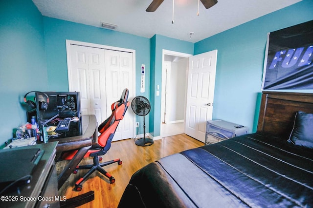 bedroom with ceiling fan, wood-type flooring, and a closet