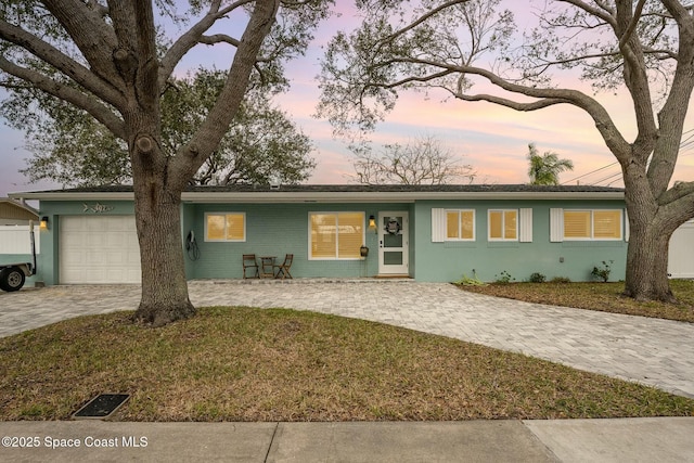 single story home with a lawn and a garage