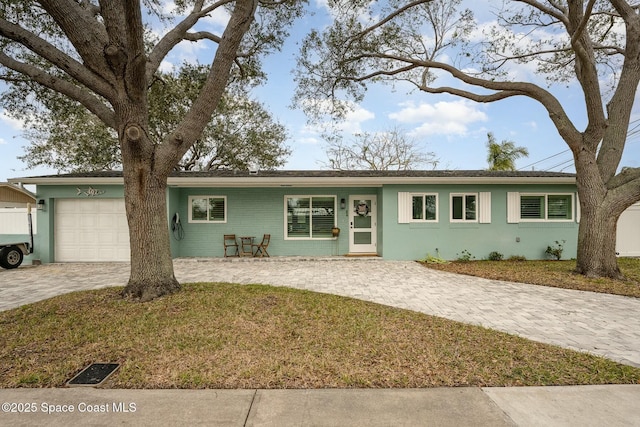 single story home featuring a garage and a front yard