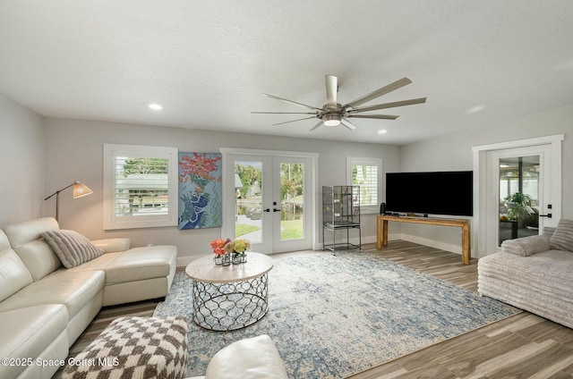 living room with a textured ceiling, ceiling fan, french doors, and hardwood / wood-style floors