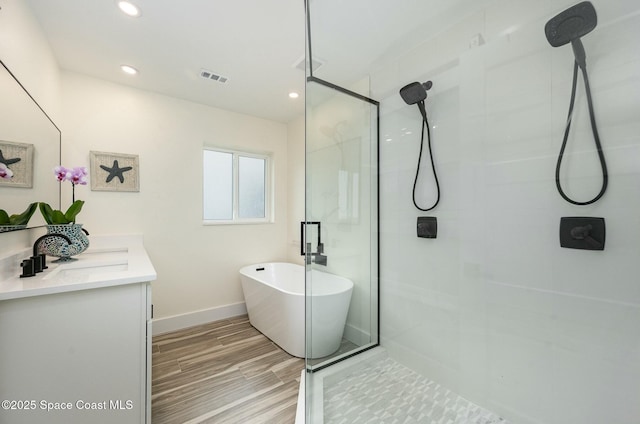 bathroom featuring vanity, hardwood / wood-style floors, and separate shower and tub