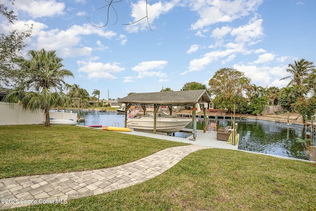 view of dock with a lawn and a water view