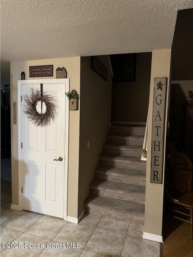 staircase featuring a textured ceiling and tile patterned floors