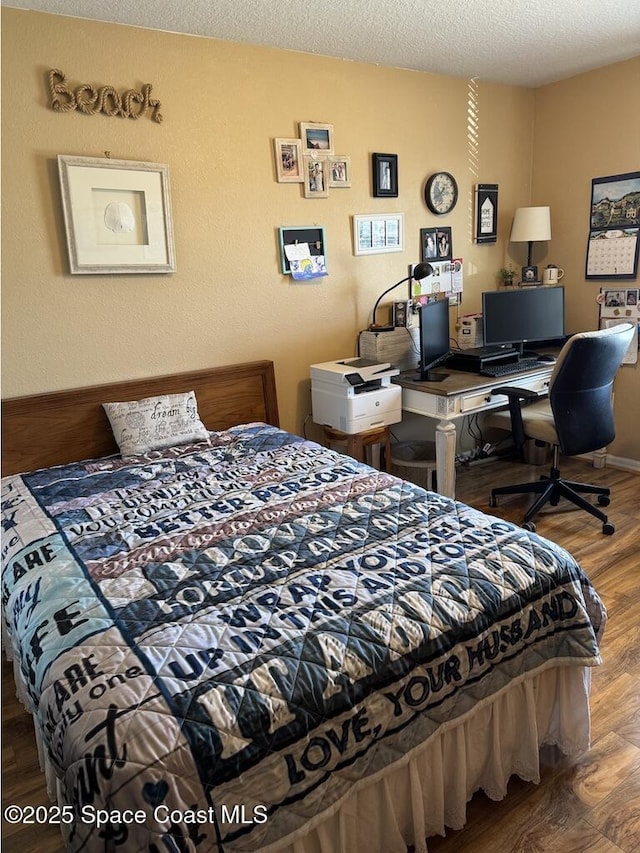 bedroom with a textured ceiling and hardwood / wood-style floors