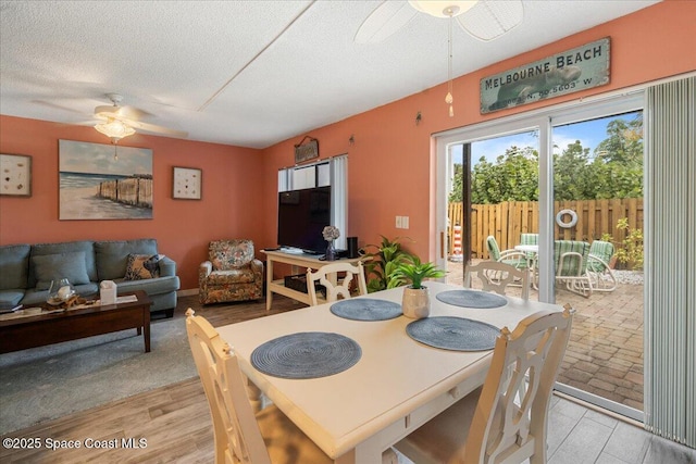 dining area featuring a textured ceiling, ceiling fan, and light wood-type flooring