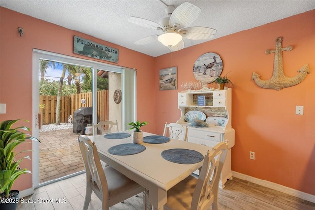 dining space featuring ceiling fan and a textured ceiling