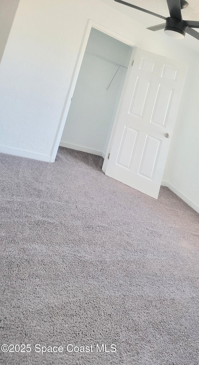 interior space with ceiling fan and carpet