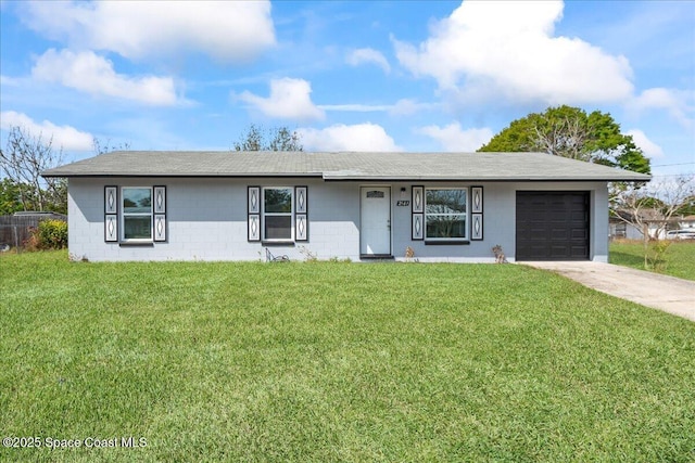 single story home with a front yard, concrete block siding, an attached garage, and concrete driveway