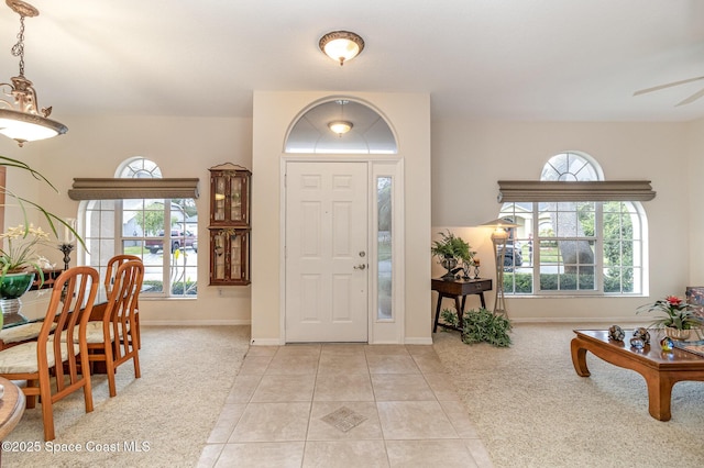 entryway featuring ceiling fan and light colored carpet