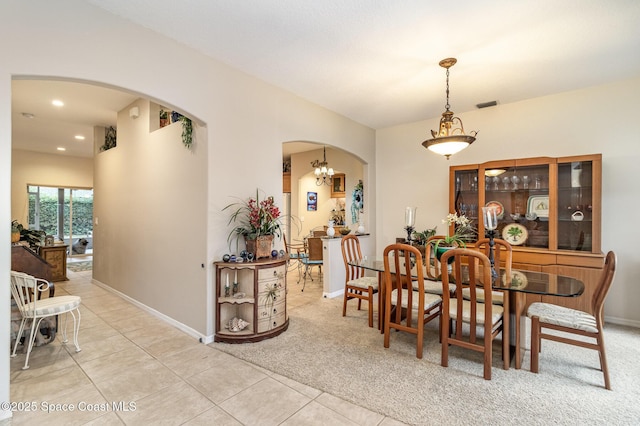 dining area with light tile patterned floors and a chandelier