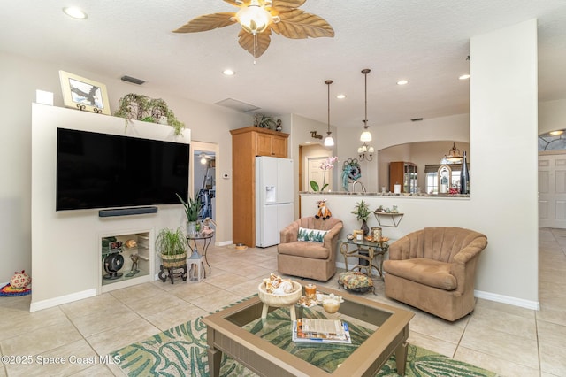 tiled living room featuring a textured ceiling and ceiling fan