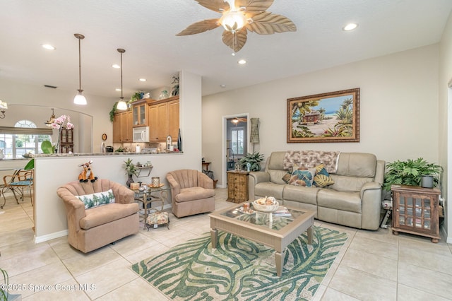 tiled living room with ceiling fan and a textured ceiling