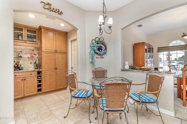 tiled dining space with a chandelier