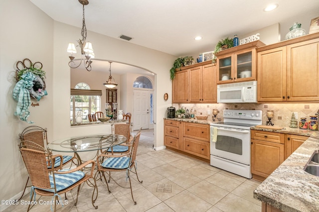 kitchen with decorative backsplash, white appliances, light stone countertops, a chandelier, and pendant lighting