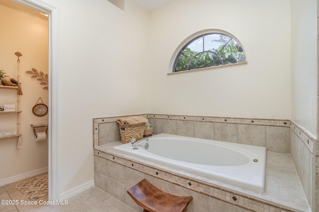 bathroom with tiled tub and tile patterned flooring